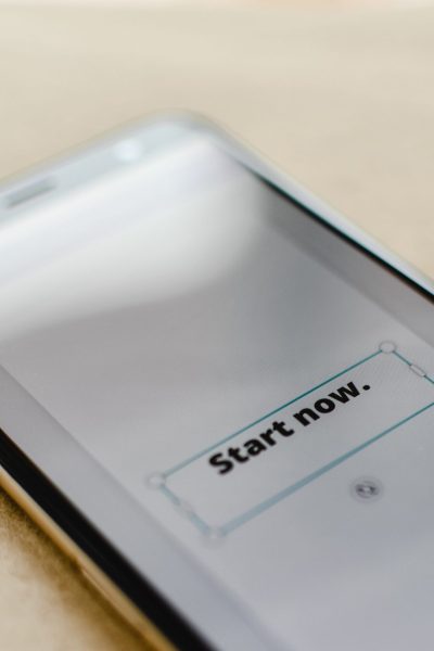 Smartphone with "Start Now" graphic showing on the screen