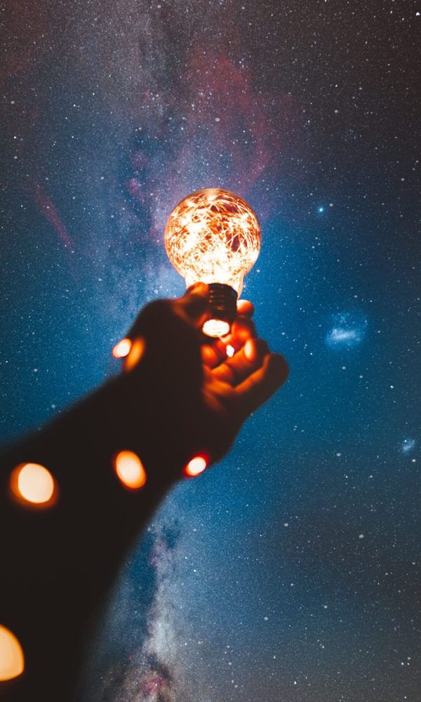 Hand holding illuminated lightbulb